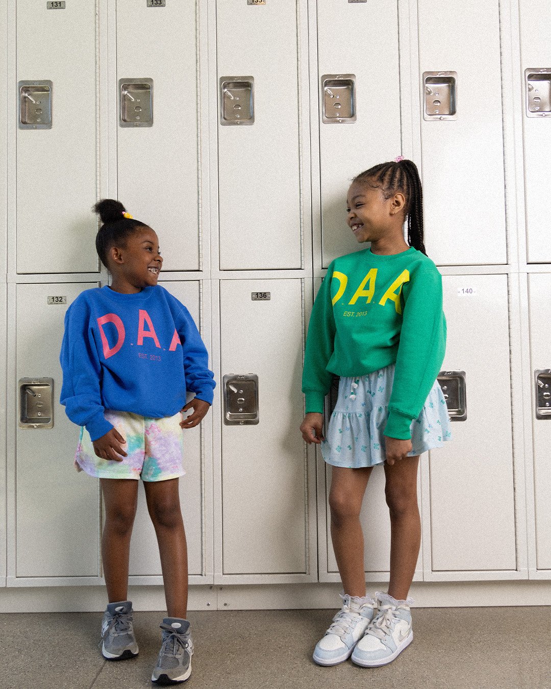 Two Detroit Achievement Academy students in D.A.A. crewnecks by the lockers
