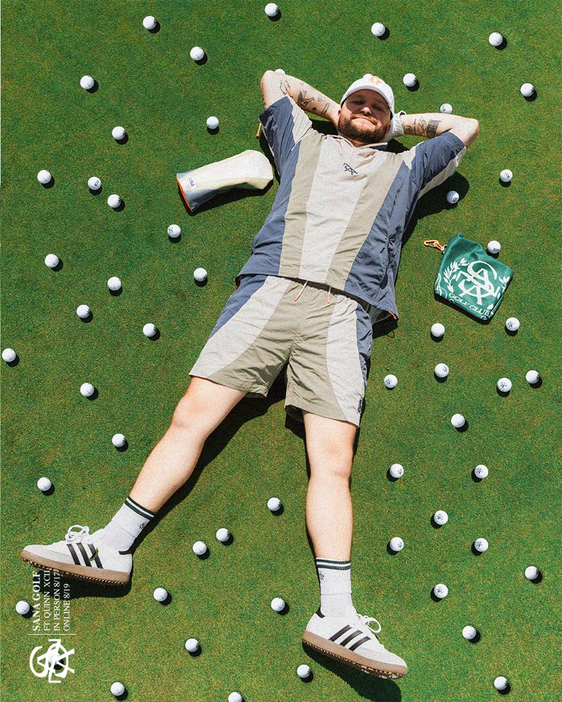 Golfer lying on the green surrounded by golf balls, with a SANA Golf Club towel
