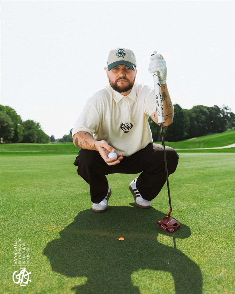 Crouching on the green in the SANA crest polo and cap