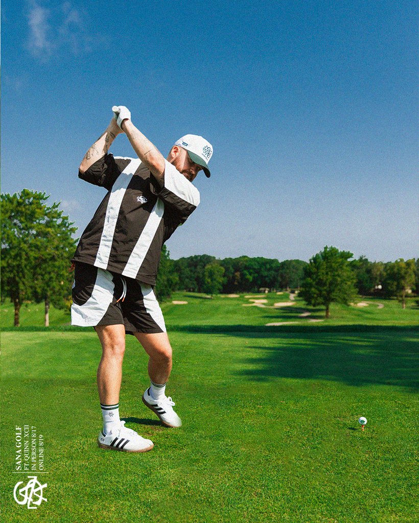 Mid-swing on the tee in the black and white SANA set